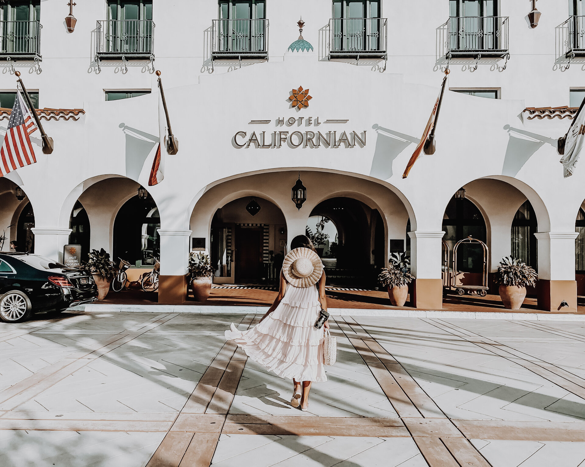 person in dress walking toward hotel californian