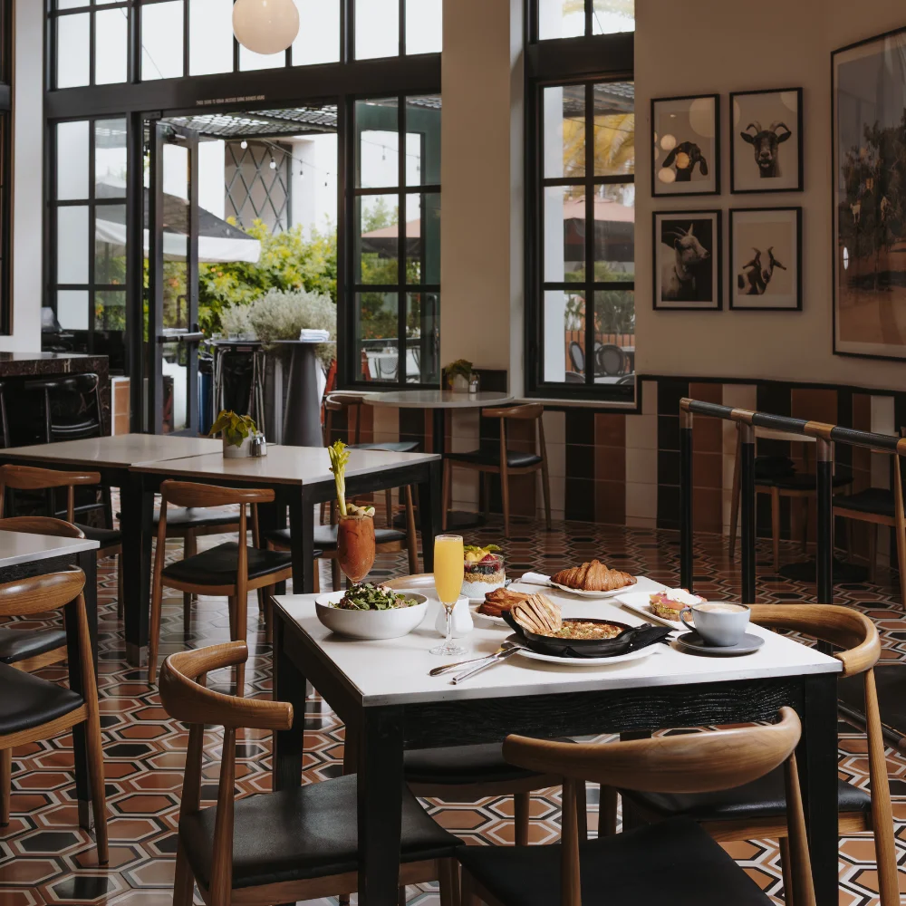 a dining area with tables set for breakfast
